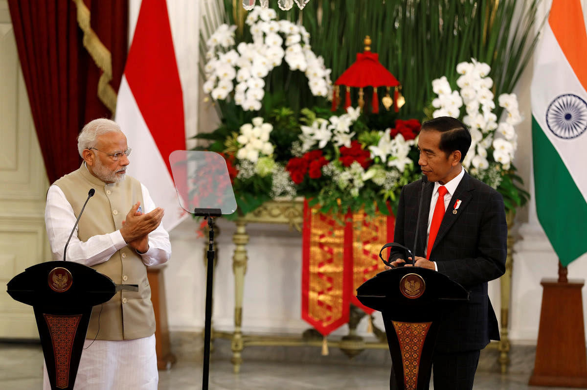 Indian Prime Minister Narendra Modi applauds Indonesia President Joko Widodo after he made an address following their meeting at the presidential palace in Jakarta, Indonesia on Wednesday. (REUTERS/Darren Whiteside)