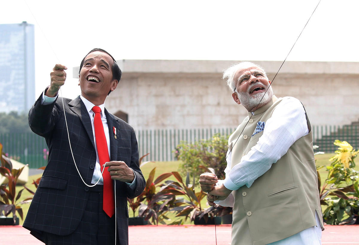 Indonesia President Joko Widodo and Indian Prime Minister Narendra Modi fly a kite at National Monument in Jakarta, Indonesia on Wednesday. (REUTERS/Beawiharta)