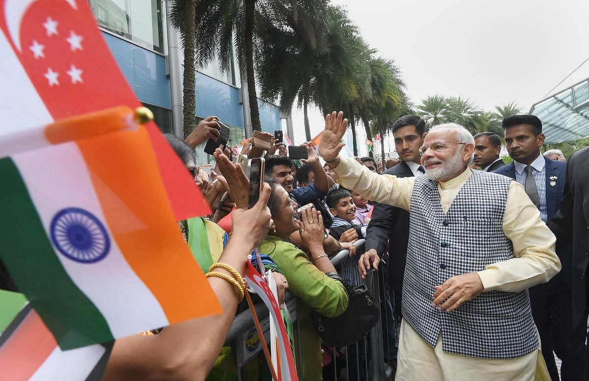 Prime Minister Narendra Modi being welcomed by the members of Indian community on his arrival, in Singapore. PTI Photo/PIB