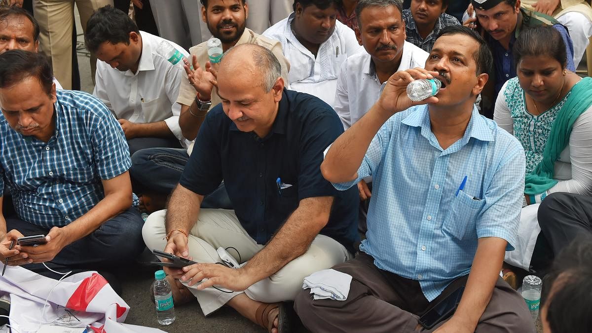In this file photo dated May 14, 2018, Delhi Chief Minister Arvind Kejriwal with Deputy CM Manish Sisodia and party workers sit on a dharna outside Lieutenant-Governor Anil Baijal's House to discuss the acrimony over the issue of setting up of CCTV camera