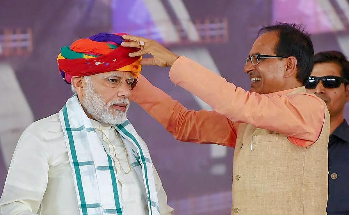 Prime Minister Narendra Modi being presented a turban by Madhya Pradesh Chief Minister Shivraj Singh Chouhan during the inauguration of Mohanpura Irrigation Project, in Rajgarh on Saturday. PTI