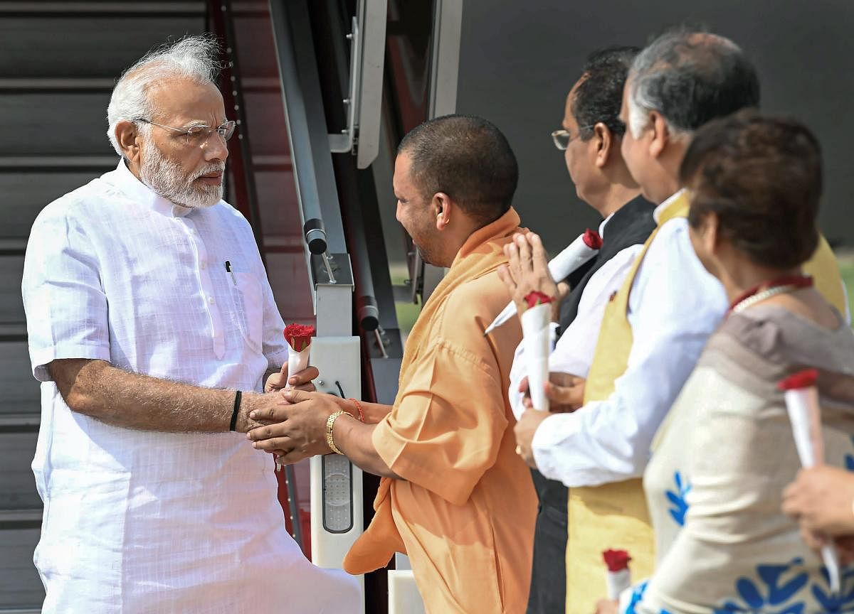 Prime Minister Narendra Modi being greeted by Uttar Pradesh Chief Minister Yogi Adityanath, on his arrival in Lucknow on Thursday. (PTI Photo)