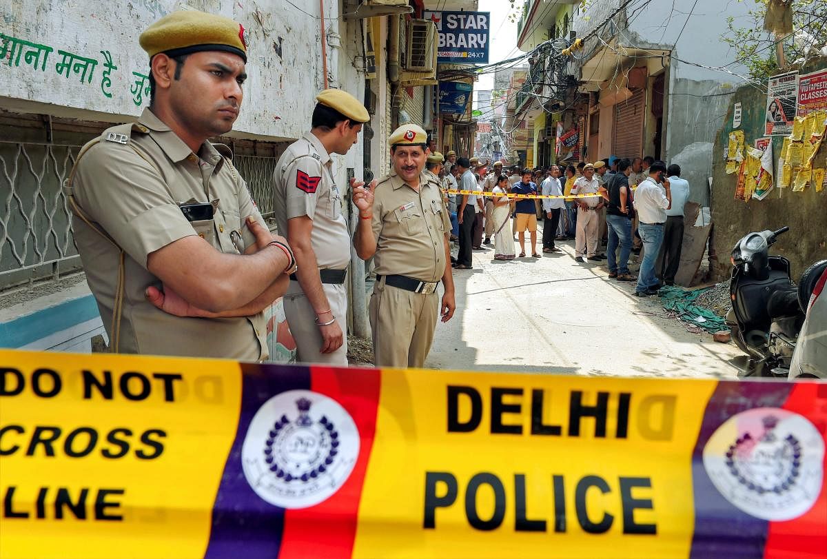 Police personnel guard near the house, where 11 members of a family- four men, three women and four girls- were found hanging from an iron grill, in Burari area of New Delhi on Sunday, July 1, 2018. (PTI Photo)