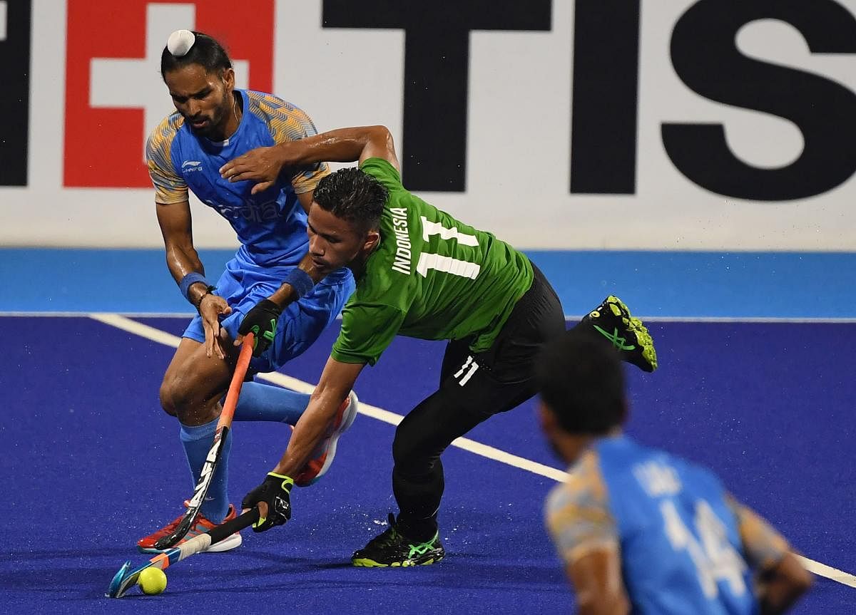 SWIFT India’s Akashdeep Singh (left) and Indonesia’s Ardam vie for the ball during their men’s Pool ‘A’ match. AFP