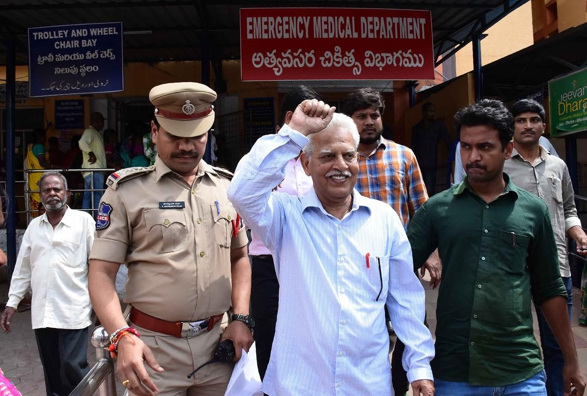 Poet and activist Varara Rao (C) gestures as he is escorted by policemen as he is arrested in Hyderabad. Police arrested prominent lawyers and left-wing activists Tuesday for alleged links to Maoist rebels, drawing a rebuke from rights watchdogs who label