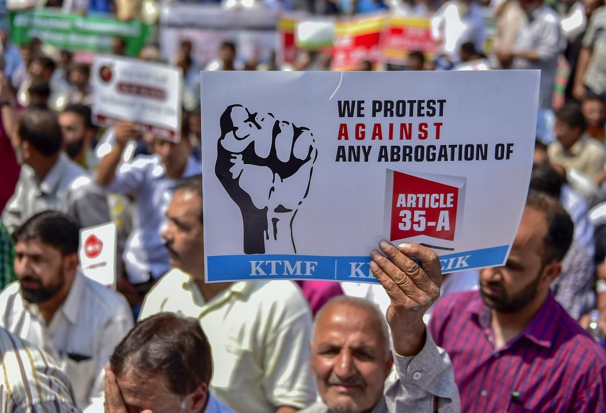 Kashmir traders raise slogans during a protest march against the petitions in the Supreme court challenging the validity of Article 35A, in Srinagar on Wednesday. PTI