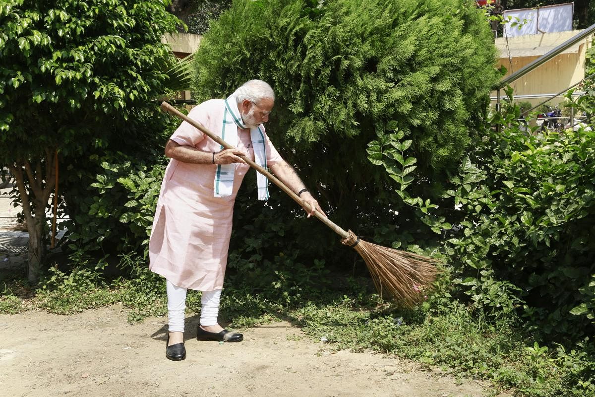 Prime Minister Narendra Modi undertakes a cleanliness drive under 'Swachhta Hi Sewa' campaign in the premises of Baba Sahib Ambedkar Higher Secondary School at Paharganj, New Delhi, on Saturday. PTI