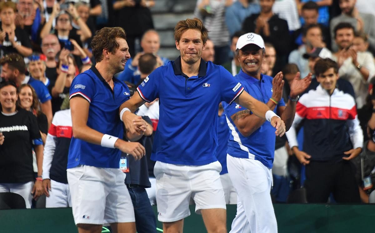 DONE AND DUSTED: France’s Nicolas Mahut (centre) and team-mate Julien Benneteau (left) celebrate with team captain Yannick Noah after their doubles win against Spain that helped them take an unbeatable 3-0 lead, on Saturday. AFP