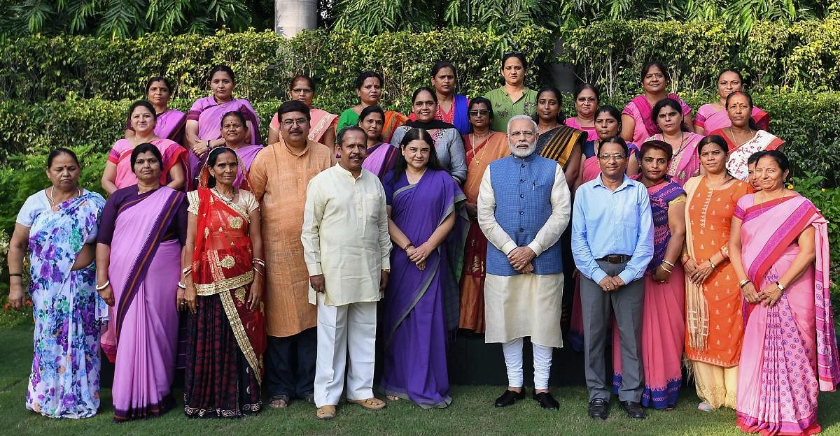 Prime Minister Narendra Modi poses for photos with Anganwadi workers from across the country, in New Delhi on Wednesday, Sept 19, 2018. Union Minister for Women and Child Development Maneka Sanjay Gandhi is also seen. PTI