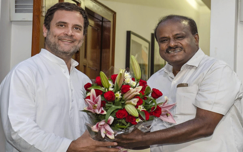 JD(S) leader and chief minister-designate H D Kumaraswamy presents a bouquet to Congress president Rahul Gandhi during a meeting in New Delhi on Monday. PTI 