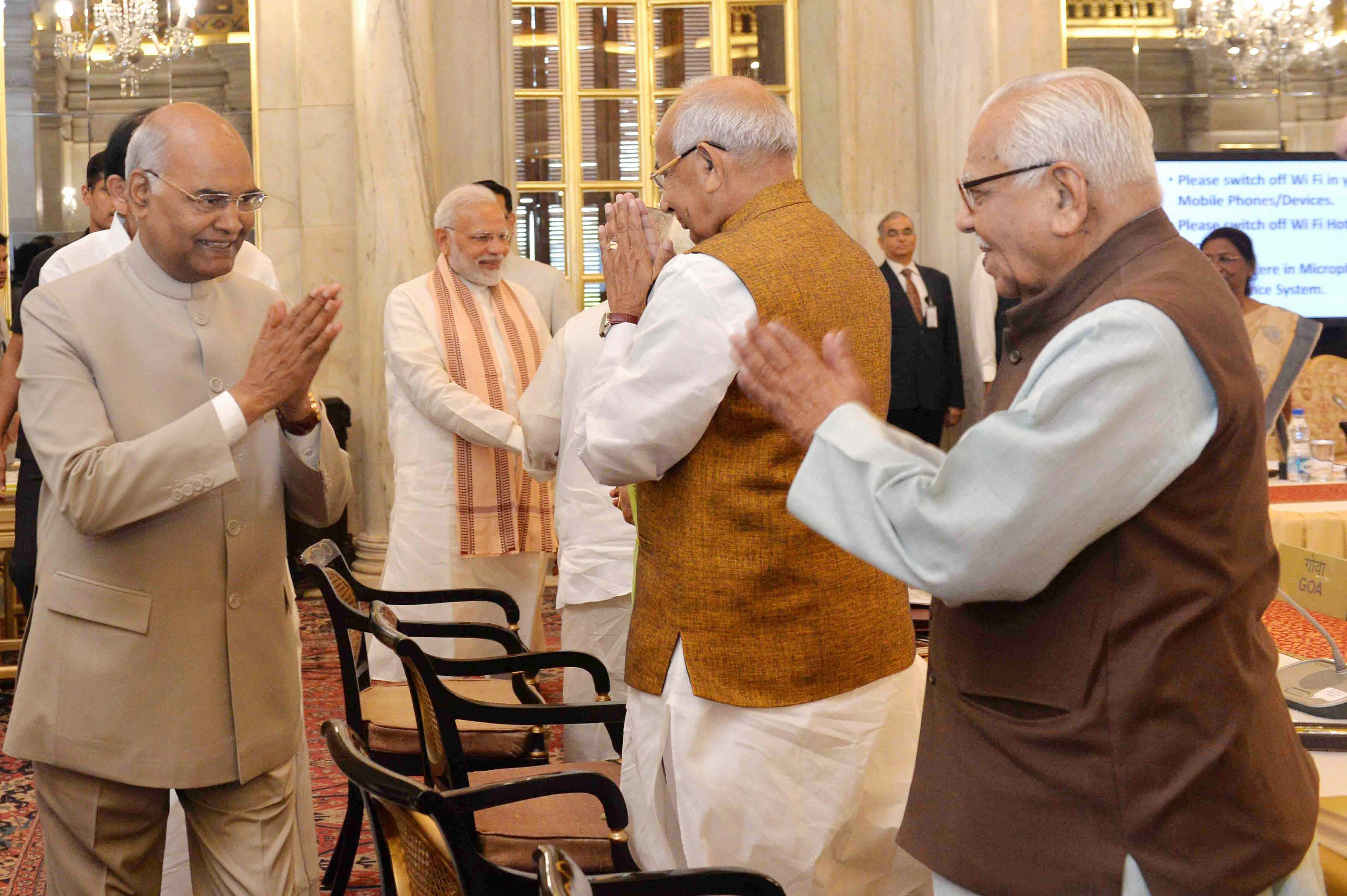 President Ram Nath Kovind exchanges greetings with Governors Kaptan Singh Solanki and Ram Naik at the Conference of Governors at Rashtrapati Bhavan, in New Delhi on Monday. PTI