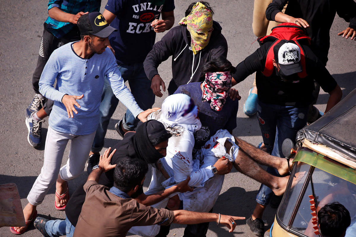 Protesters carry an injured man who according to local media was hit by a Central Reserve Police Force (CRPF) vehicle during a protest after Friday prayers. Reuters photo.
