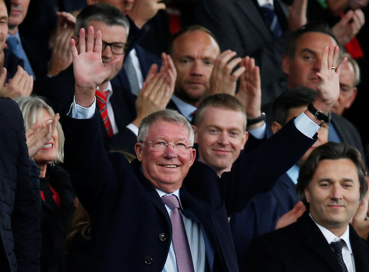BACK Alex Ferguson waves to the fans at Old Trafford after making his first appearance at the club since undergoing emergency brain surgery in May. REUTERS
