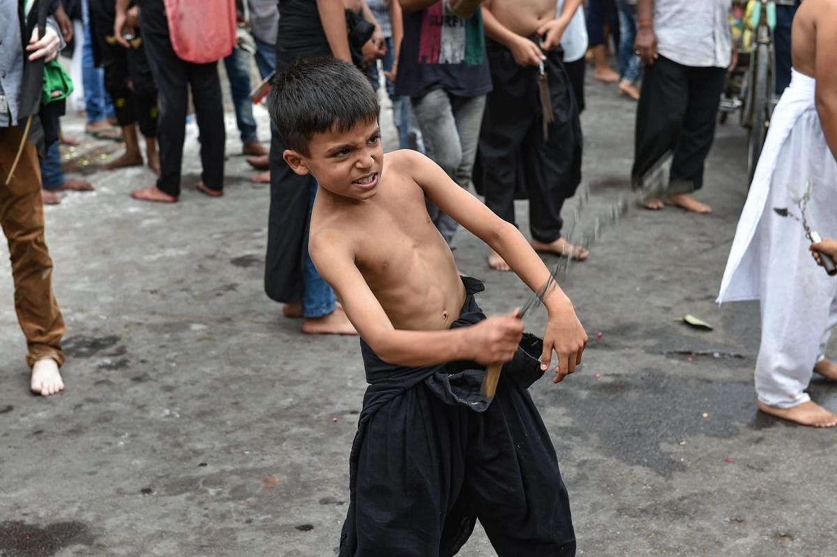 Lucknow: A Shia Muslim boy flagellates himself while participating in a Muharram procession in Lucknow, Friday, Sept 21, 2018. (PTI Photo/Nand Kumar)
