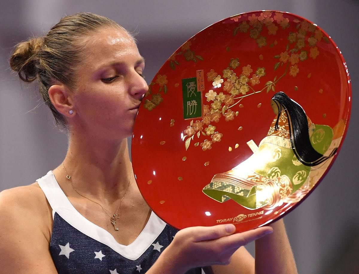 TOO GOOD Karolina Pliskova of the Czech Republic kisses the winner's trophy after beating Japan's Naomi Osaka in the final of the Pan Pacific Open in Tokyo on Sunday. AFP