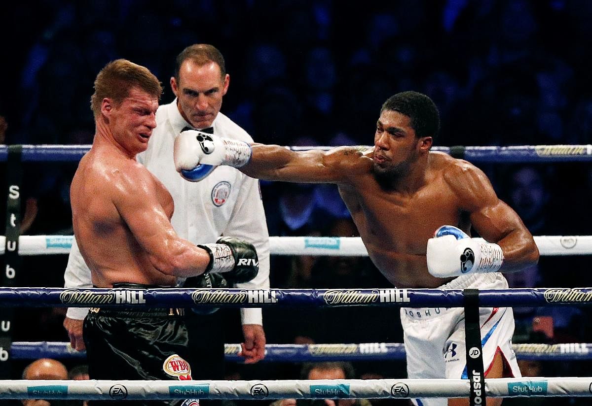 TAKE THAT Russia's Alexander Povetkin knocked down to the canvas as Britain's Anthony Joshua lands a punch during their boxing world heavyweight title fight in London on Saturday. AFP