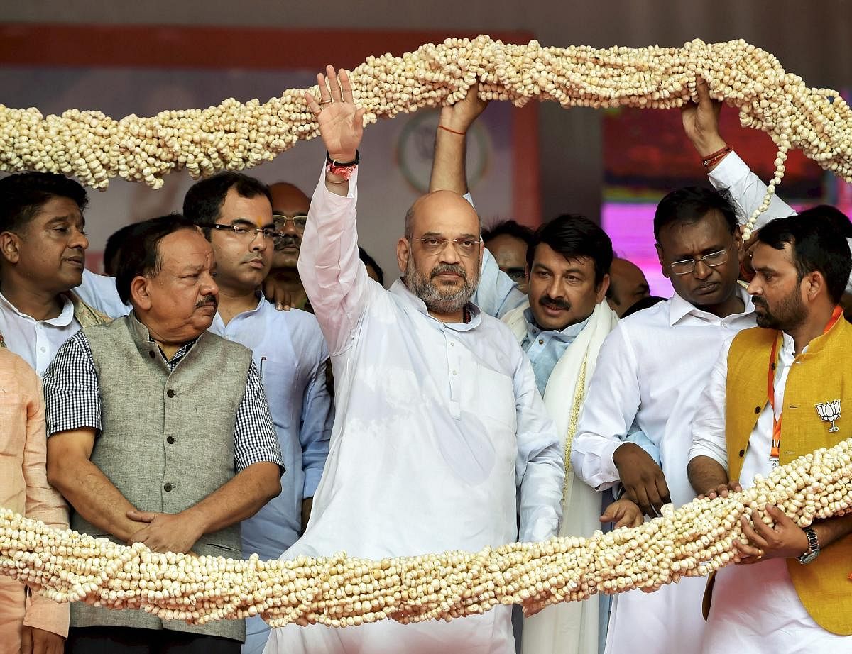 BJP President Amit Shah with other senior leaders being garlanded during the Purvanchal Mahakumbh, at Ramleela Maidan in New Delhi on Sunday. PTI
