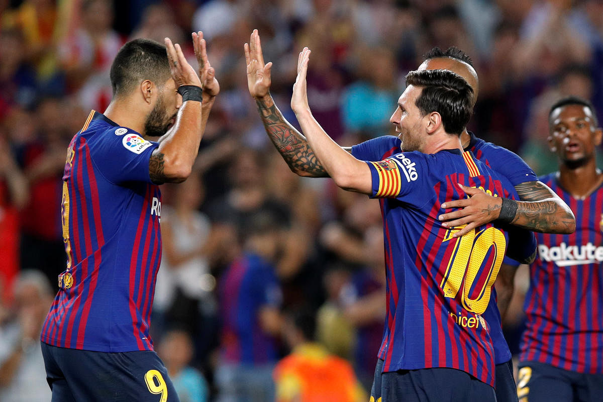 Barcelona's Lionel Messi celebrates with team-mates Luis Suarez (left) and Arturo Vidal after scoring against Girona on Sunday. REUTERS