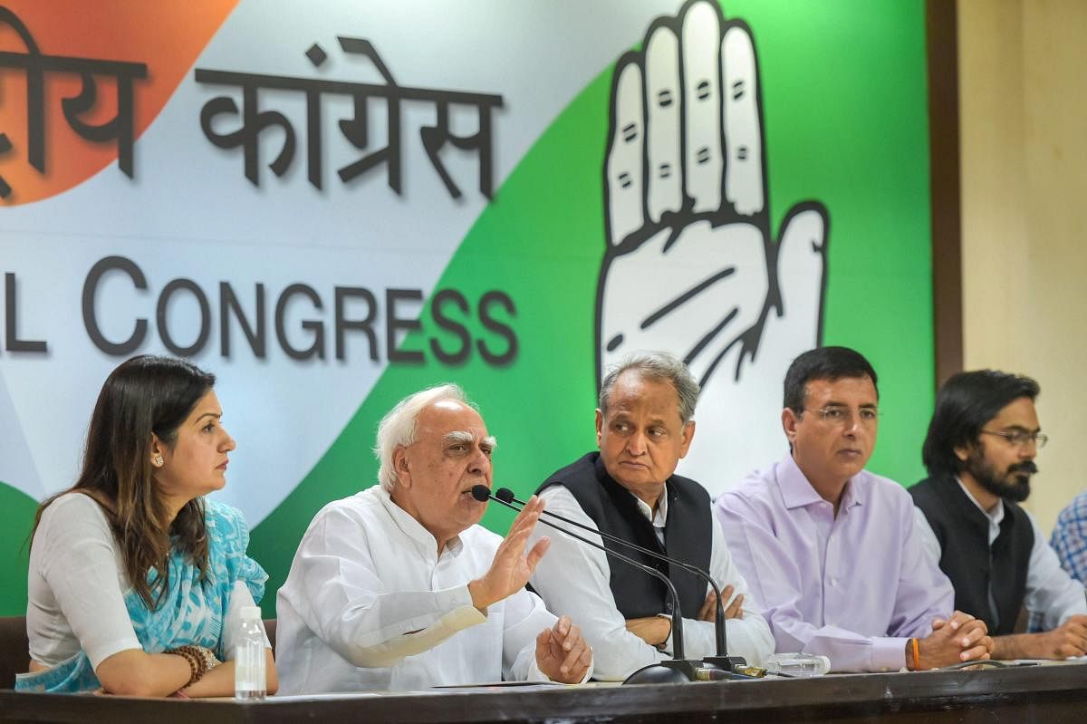 Congress leader Kapil Sibal speaks as Ashok Gehlot, Randeep Singh Surjewala and others look on during a press conference at AICC, in New Delhi, on Wednesday. (PTI Photo)