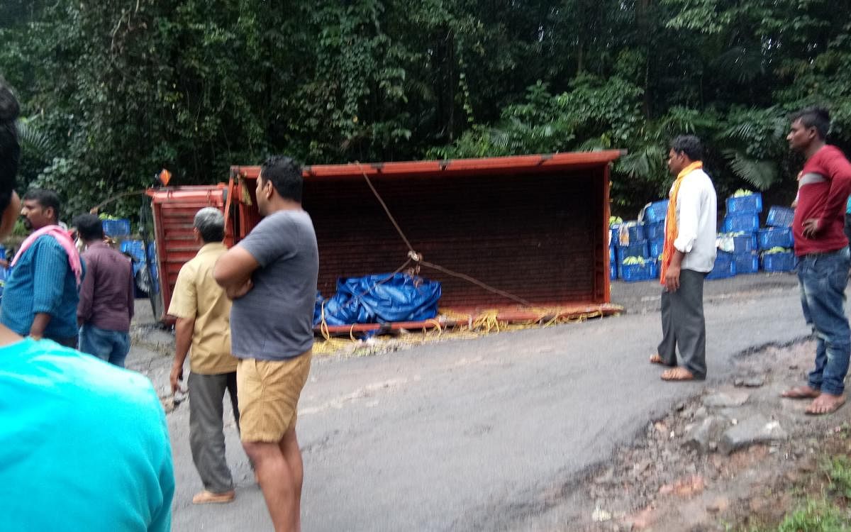 A lorry overturns on a Charmadi Ghat road on Wednesday morning.