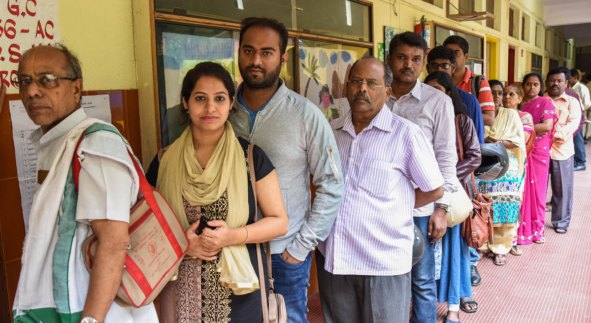 Voters queue up at a polling booth to exercise their franchise for the Bangalore graduates’ constituency elections on Friday. DH PHOTO