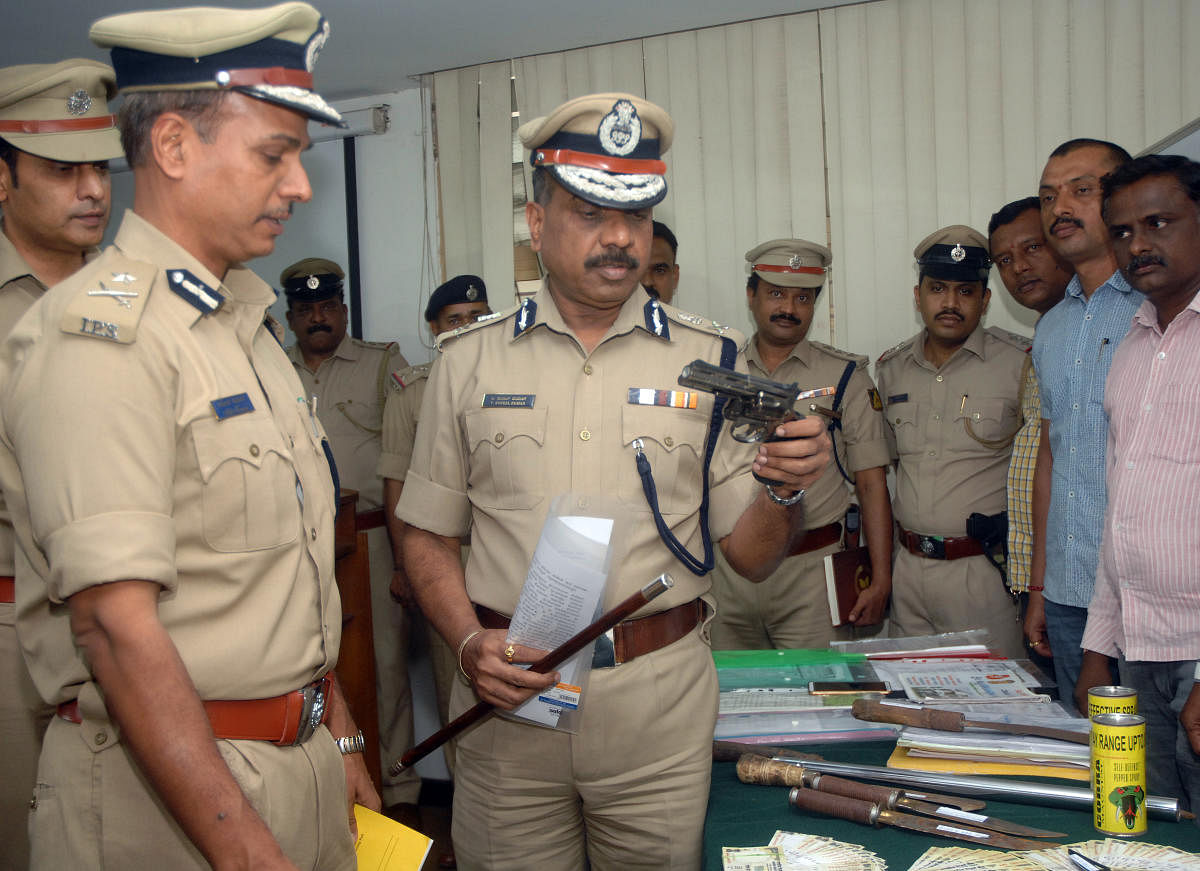 Police Commissioner T Suneel Kumar and Additional Commissioner of Police (Crime) Alok Kumar look at pistols, knife and property documents seized from rowdies houses in the city on Thursday.