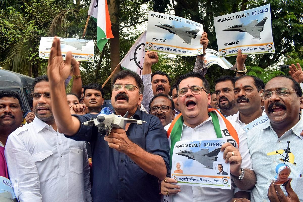NCP workers raise slogans and placards during a protest against the alleged scam in Rafale deal, in Thane, on Friday. PTI