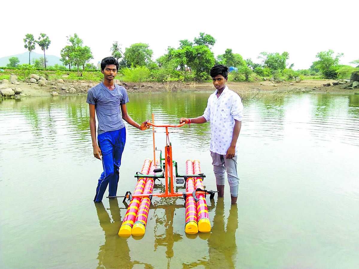 Polytechnic students Tamil Kumaran and Guna seen with their invention, a bicycle that moves on water.