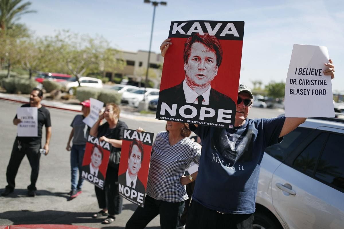 People hold signs during a protest against Supreme Court nominee Brett Kavanaugh outside the offices of Sen. Dean Heller, R-Nev., in Las Vegas. (AP/PTI Photo)