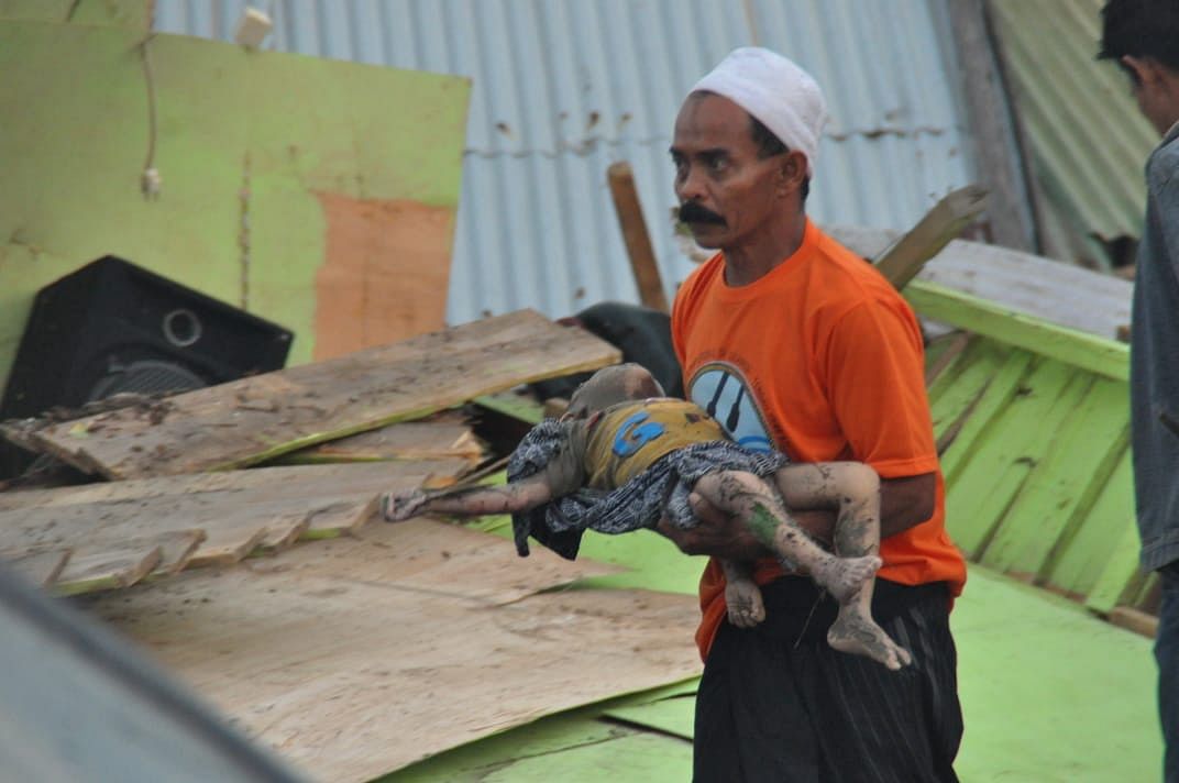 A man carries the body of a child after an earthquake and tsunami hit Palu, on Sulawesi island, on Saturday. (AFP)