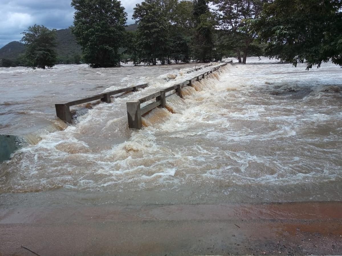 The Palamadu bridge is submerged at Hoggenkkal in Hanur taluk of Chamarajanagar district as water level in the River Cauvery increased on Thursday. DH Photo.
