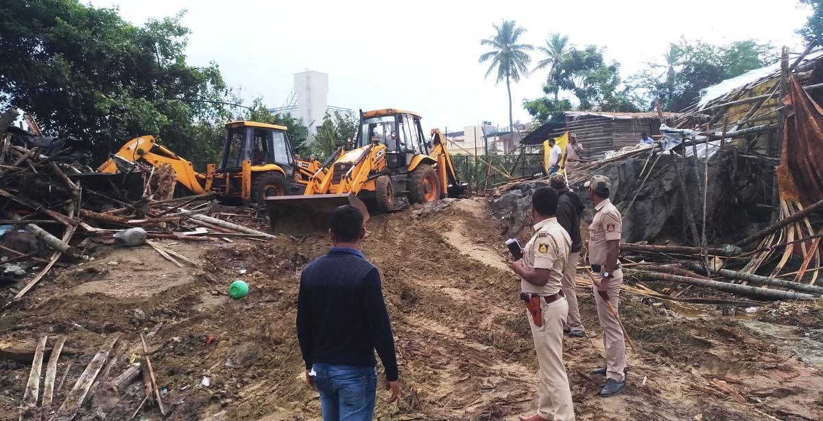 Illegally constructed huts being cleared at Idgah Nagar in Kadur.