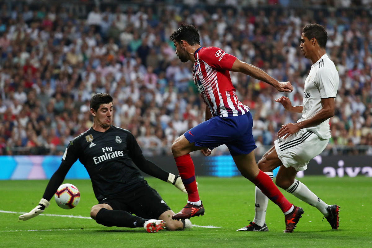 Real Madrid's Thibaut Courtois (left) makes an exceptional save off against Atletico Madrid's Diego Costa during their La Liga clash on Saturday. REUTERS