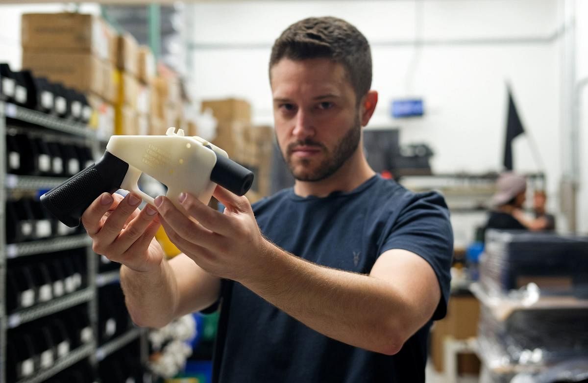 Cody Wilson, owner of Defense Distributed company, holds a 3-D printed gun, called the "Liberator", in his factory in Austin, Texas on August 1, 2018. AFP