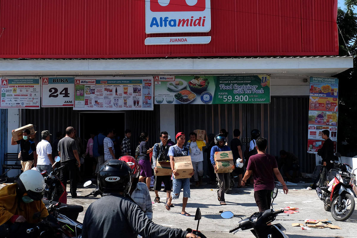 People make off with goods from a shop in earthquake and tsunami-devastated Palu, Central Sulawesi, Indonesia September 30, 2018. (REUTERS/Stringer)