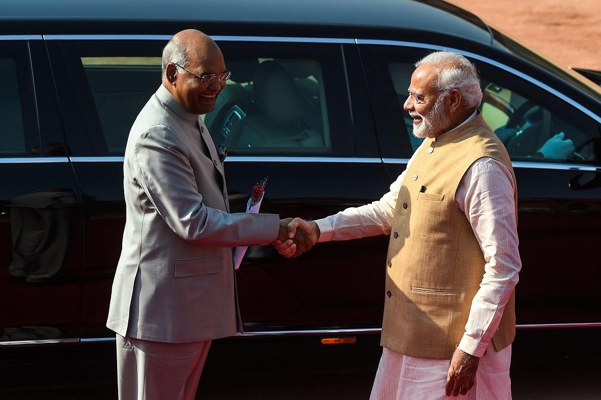 Prime Minister Narendra Modi shakes hands with India's President Ram Nath Kovind. (AFP Photo)