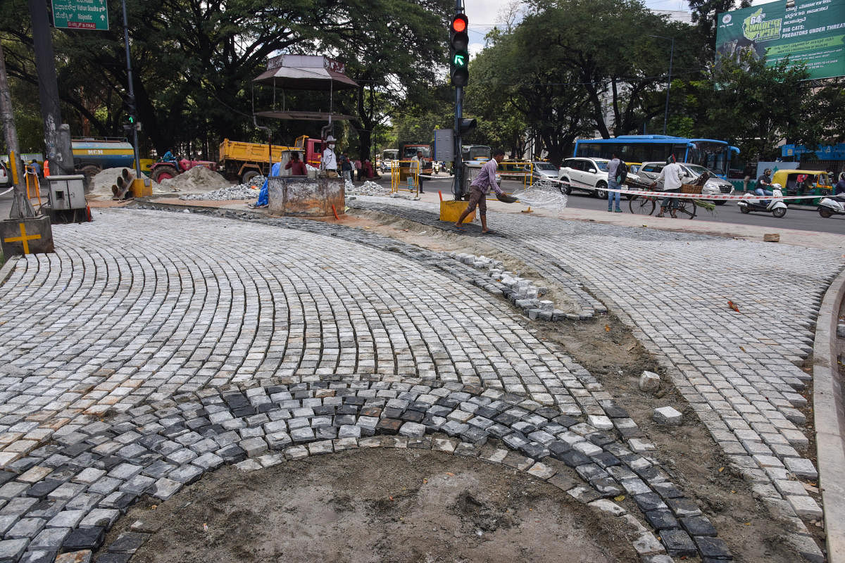 BBMP workers lay Cobblestones at Hudson circle on Monday. (DH Photo/SK Dinesh)