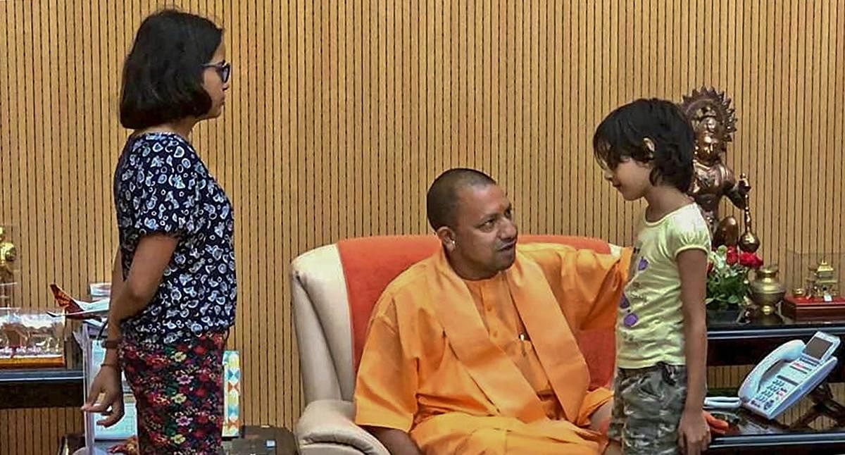 Uttar Pradesh Chief Minister Yogi Adityanath interacts with the children of the private company executive Vivek Tiwari, who was reportedly shot at by a police constable, in Lucknow on Monday. PTI