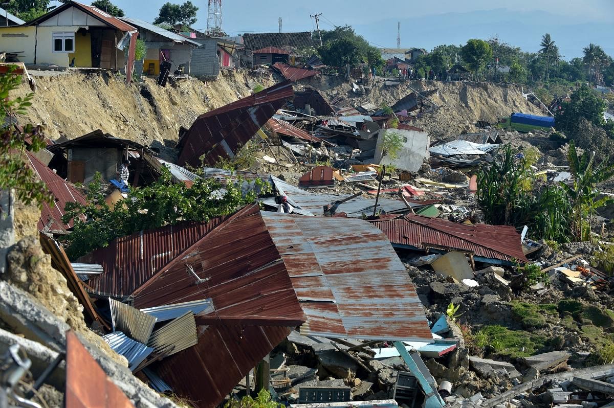 Damaged houses are seen in Palu, Indonesia's Central Sulawesi on October 1, 2018, after an earthquake and tsunami hit the area on September 28. - Indonesian volunteers began burying bodies in a mass grave with space for more than a thousand people on Octo