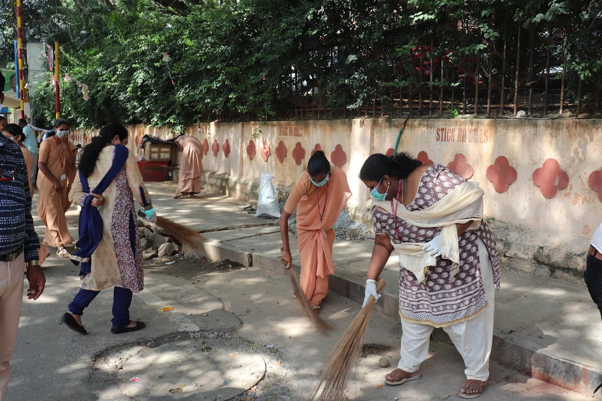 Students and staff of Mt Carmel College clean the neighbourhood as part of Gandhi Jayanti on Tuesday.