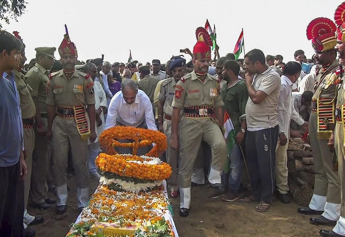 An official pays tribute to BSF head constable Narender Singh after his mortal remains arrived in his native village in Sonipat, Thursday, Sep 20, 2018. The body of Narender Singh, who had gone missing the near the international border in Ramgarh sector,