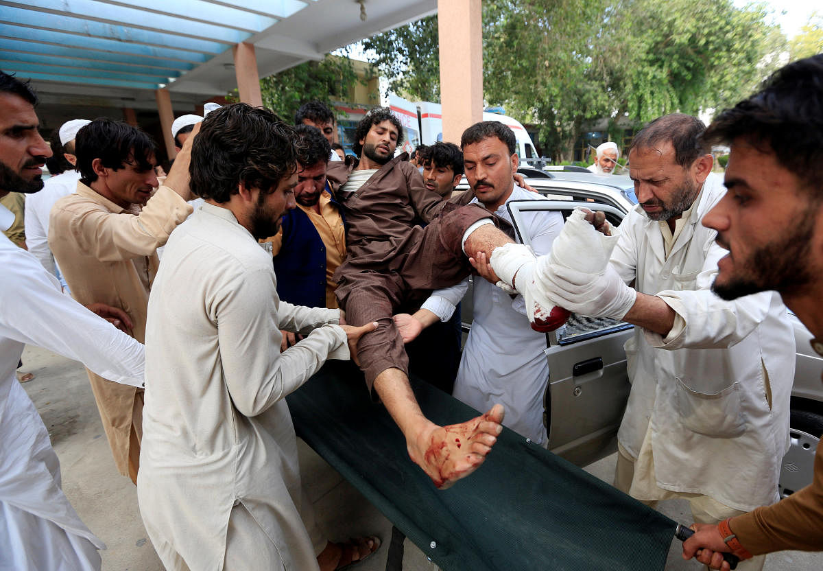 Afghan men carry an injured man to a hospital after a suicide attack in Jalalabad on October 2, 2018. Reuters