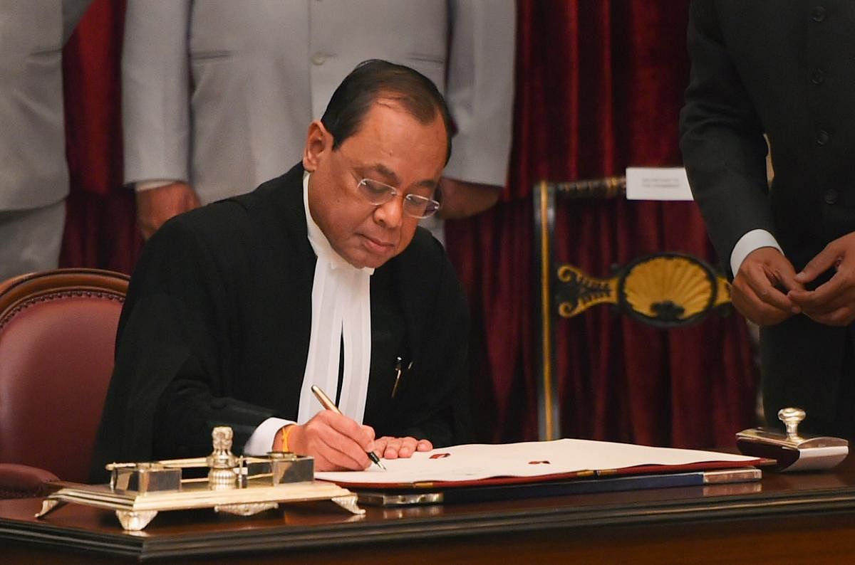 Justice Ranjan Gogoi signs the register after taking his oath of office on being appointed as the 46th Chief Justice of India, at Rashtrapati Bhawan in New Delhi, Wednesday, Oct 3, 2018. (PTI Photo)