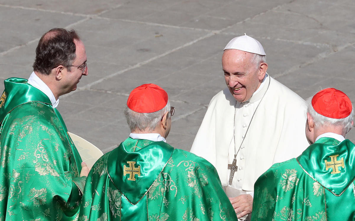 Pope Francis greets cardinals at the end of a mass for the opening of a synodal meeting in Saint Peter's square, at the Vatican. (Reuters photo)