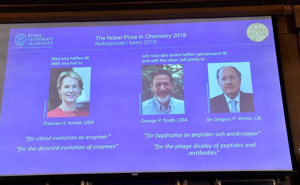 A screen displays portraits of Frances H Arnold of the United States, George P Smith of the United States and Gregory P Winter of Great Britain during the announcement of the winners of the 2018 Nobel Prize in Chemestry at the Royal Swedish Academy of Sciences on October 3, 2018 in Stockholm. (AFP photo)
