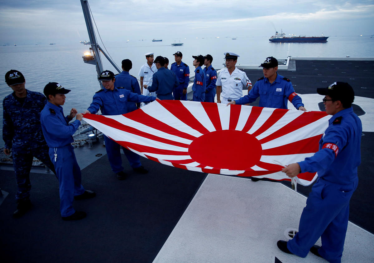 Sailors fold the Japanese naval ensign after a flag lowering ceremony on the deck of Japanese helicopter carrier Kaga anchored near Jakarta Port, Indonesia on September 21, 2018. Reuters
