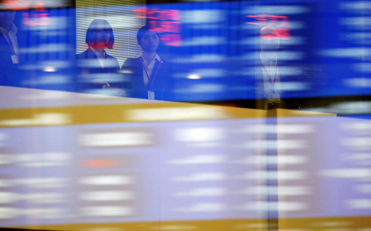 Visitors are seen as market prices are reflected in a glass window at the Tokyo Stock Exchange (TSE) in Tokyo, Japan. (REUTERS File Photo)