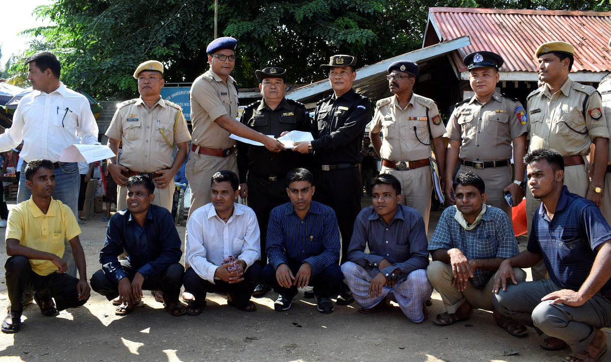 The seven Rohingya men to be deported sit as Indian and Myanmar security officials exchange documents before their deportation on India-Myanmar border at Moreh in the northeastern state of Manipur on Thursday. Reuters