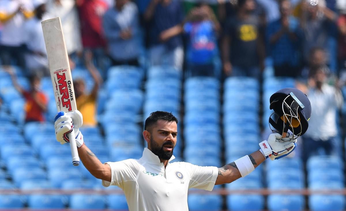 Indian cricket captain Virat Kohli celebrates after reaching his century during the second day's play of the first Test cricket match between India and West Indies at the Saurashtra Cricket Association stadium in Rajkot on October 5, 2018. (AFP Photo)