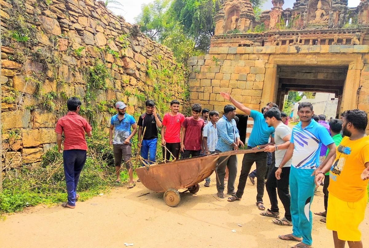  Group members clearing the bushes around a fortress in Hagalwadi, Tumakuru; a village entrance.